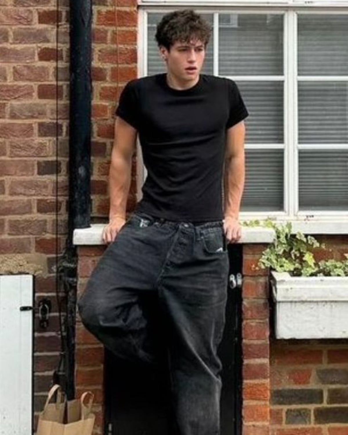 London Indie Sleaze outfit — men's fitted black crewneck t-shirt, men's baggy washed-black jeans, men's black leather boots